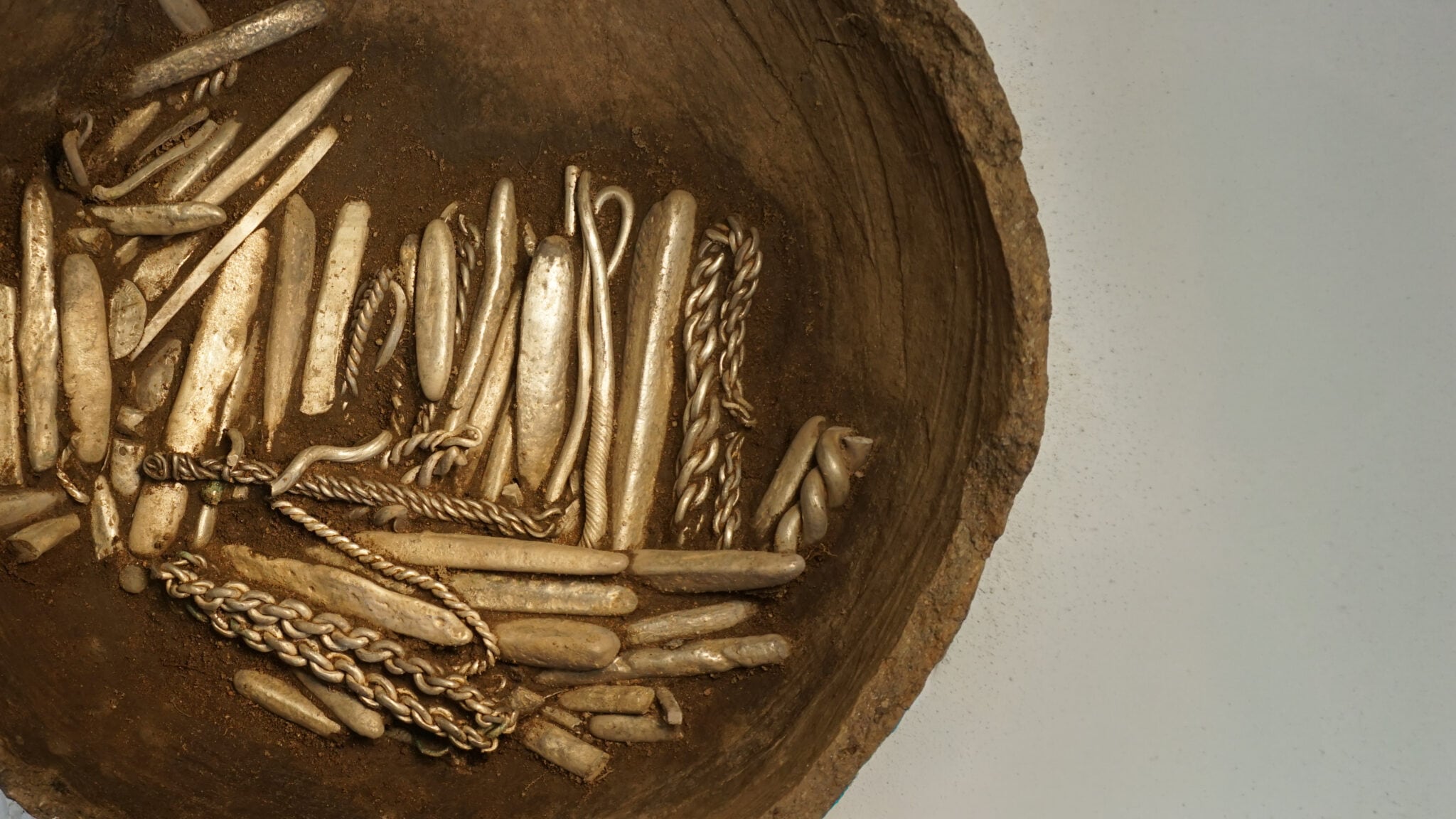 Unas 320 piezas de plata con un peso de 6,4 kilos permanecían dentro de una vasija de arcilla, mientras el resto del tesoro apareció disperso en la tierra - Gentileza: Museos del Norte de Jutlandia / Nordjyske Museer