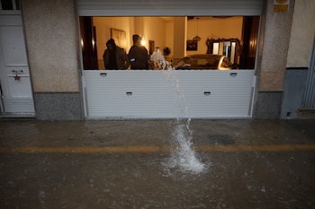 Unas personas achican agua de