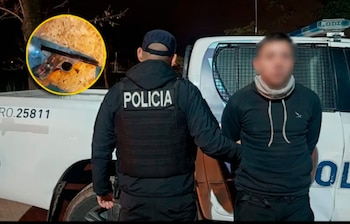 Un policía de espaldas sujeta a un hombre borroso con las manos esposadas frente a un patrullero, mientras una imagen circular inserta muestra una pistola
