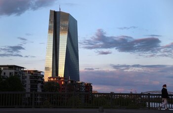 FILE PHOTO: A woman, wearing a protective mask walks past the head quarter of the European Central Bank (ECB) during sunset in Frankfurt, Germany, April 29, 2020, as the spread of the coronavirus disease (COVID-19) continues. REUTERS/Kai Pfaffenbach