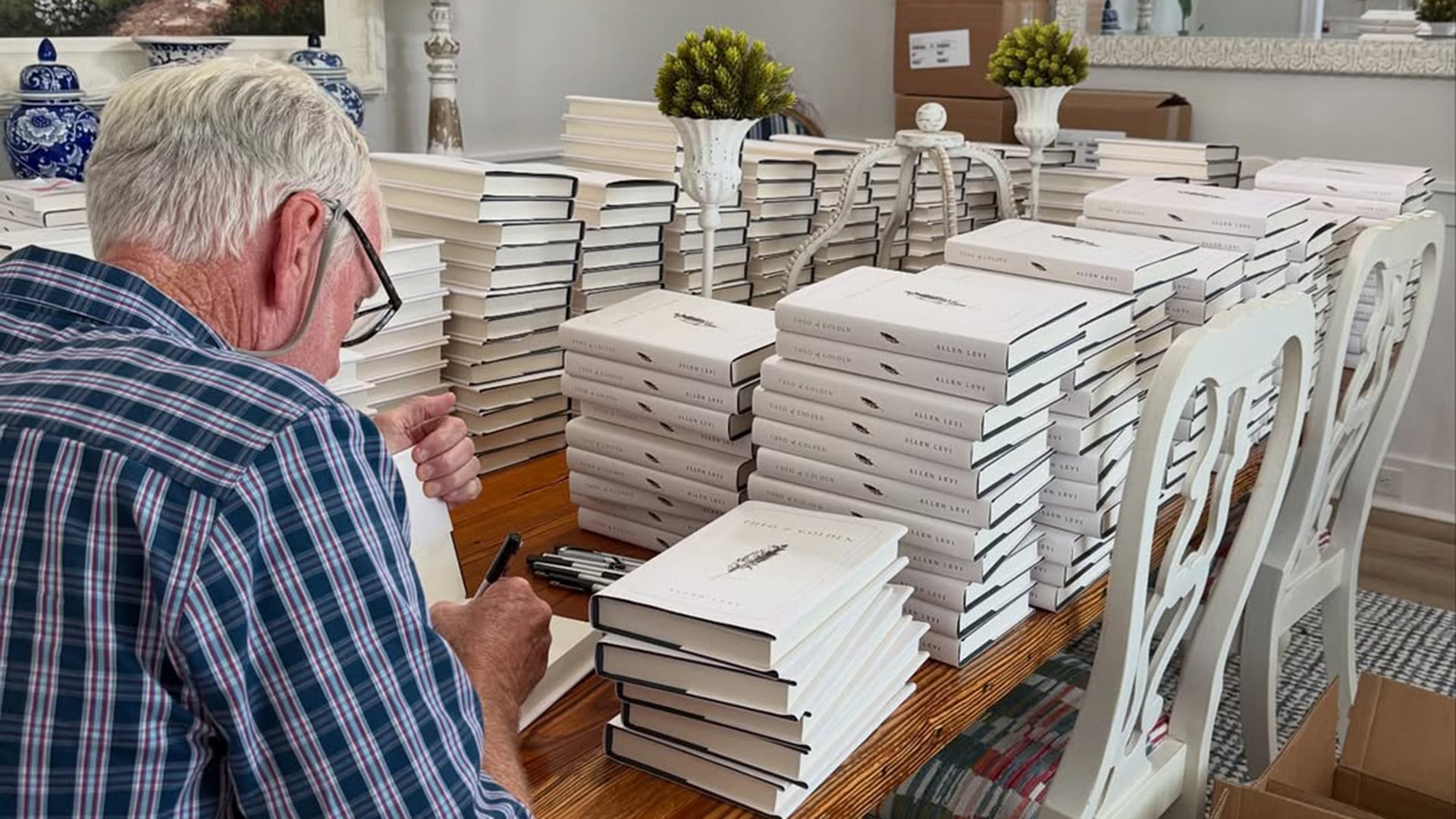 Allen Levi firmando ejemplares