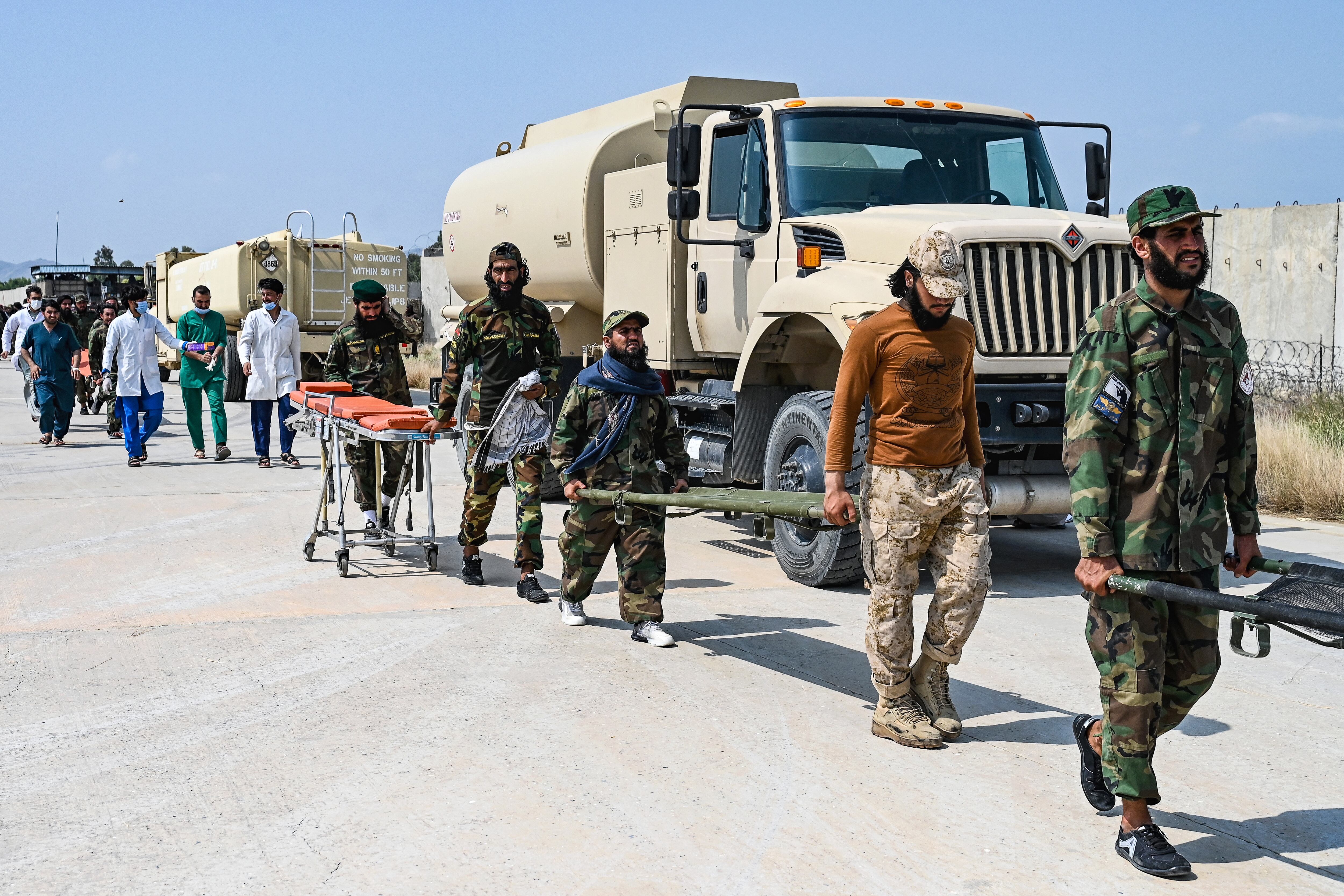 Personal médico afgano y de seguridad talibán transportan camillas para las víctimas evacuadas del terremoto a su llegada para recibir asistencia médica a Jalalabad el 1 de septiembre de 2025. Una gran operación de rescate se encontraba en marcha en Afganistán el 1 de septiembre, después de que un fuerte terremoto y múltiples réplicas arrasaran viviendas en una región montañosa remota, causando la muerte de más de 800 personas, según informaron las autoridades talibanes. (Foto de Wakil KOHSAR / AFP)