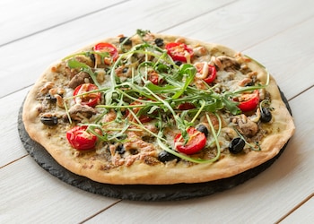 La masa de pizza al estilo romano se caracteriza por ser más fina y crujiente que la napolitana (Magnific)
