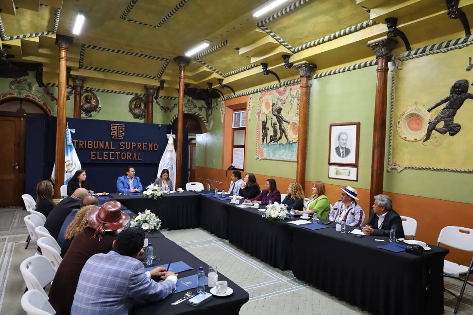 Foto de archivo para ilustrar: Magistrados del Tribunal Supremo Electoral de Guatemala en una reunión en una sala con decoraciones murales y el logo institucional, sentados alrededor de una mesa en forma de U. (Tribunal Supremo Electoral de Guatemala)