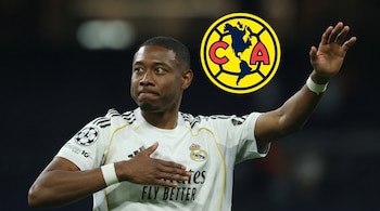 David Alaba con la camiseta blanca del Real Madrid y la mano alzada junto al escudo del Club América.