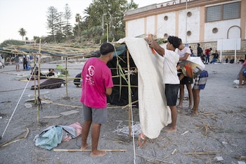 Imagen de varios migrantes en la playa del Trampolín, a 28 de agosto, en Ceuta. (Marcos Moreno / Europa Press)