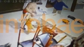 Imagen de cámara de seguridad que muestra un espacio interior con personas y objetos sobre una mesa
