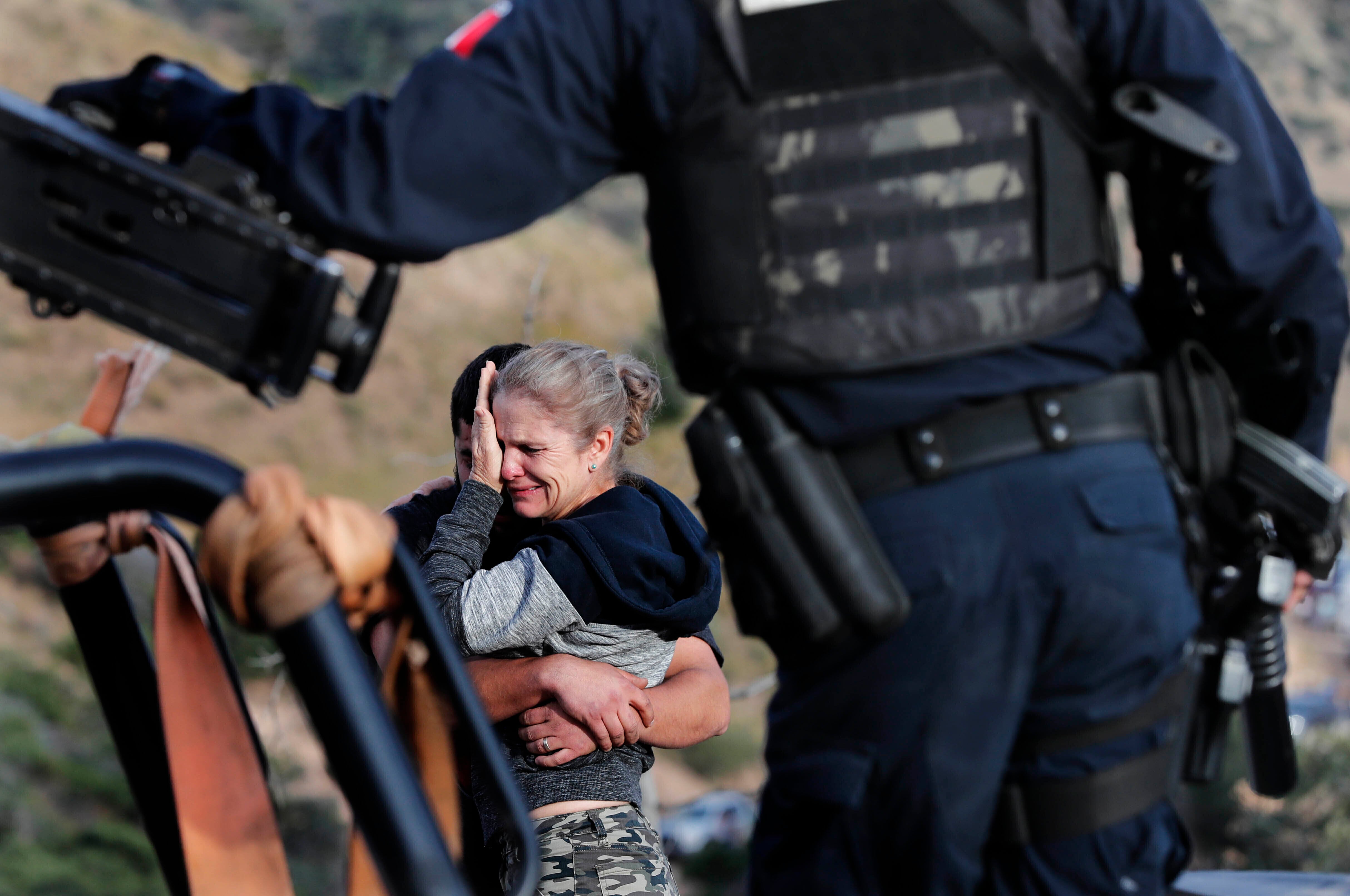 Custodiados por las fuerzas de seguridad mexicanas, miembros de la familia LeBarón lloran a sus muertos en el lugar donde nueve ciudadanos estadounidenses _ tres mujeres y seis niños _ fueron asesinados en una emboscada de un cártel, cerca de Bavispe, en la frontera entre los estados de Sonora y Chihuahua, México, el 6 de noviembre de 2019. (AP Foto/Marco Ugarte)