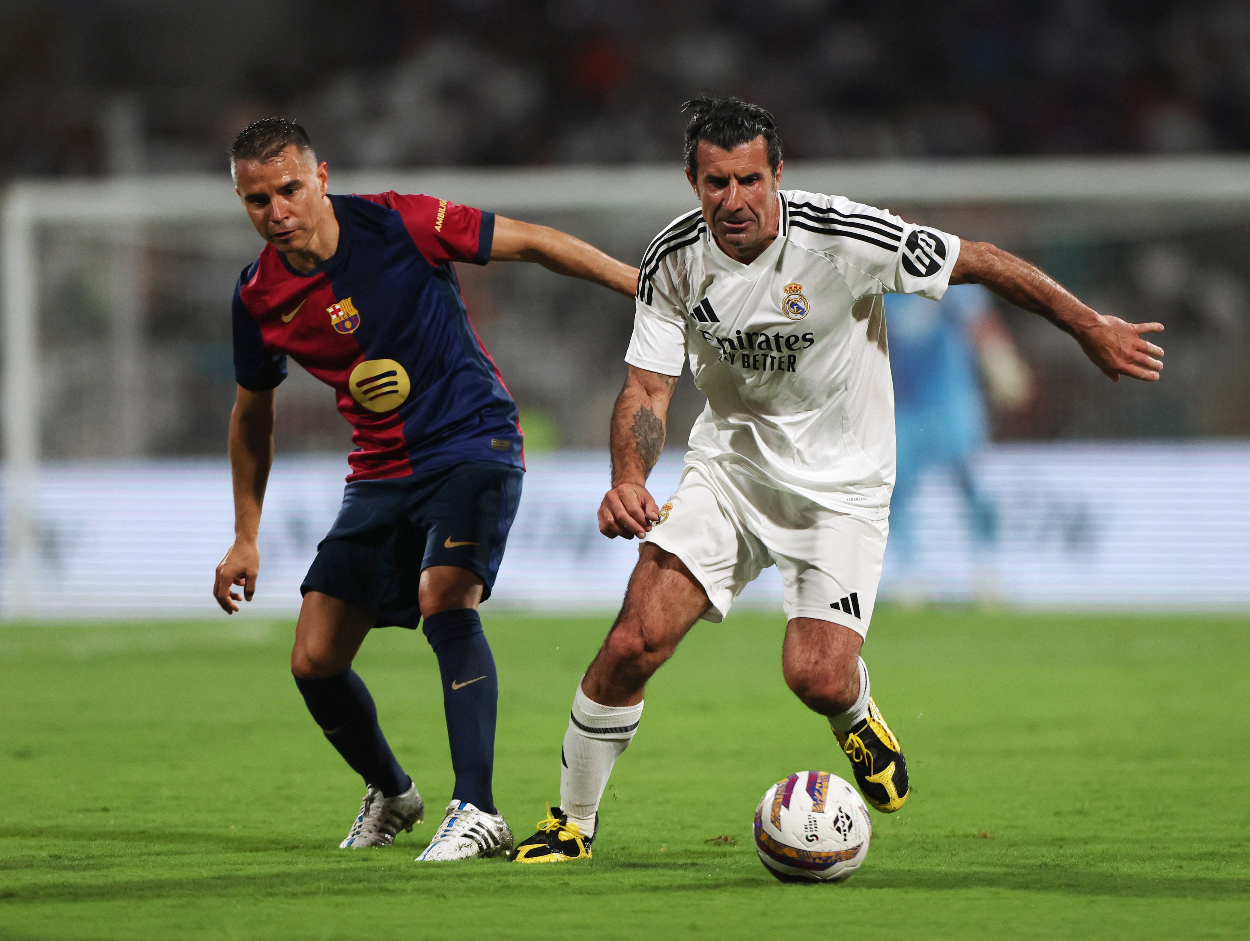 Figo, en un clásico de leyendas, con la indumentaria del Real Madrid: disputa el balón contra el Barcelona (REUTERS/Francis Mascarenhas)
