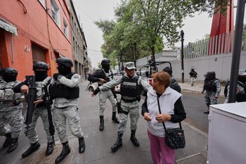 La Guardia Nacional retira a un peatón de los alrededores de la sede de la Fiscalía General en Ciudad de México, el domingo 22 de febrero de 2026, tras la muerte del líder del Cártel Jalisco Nueva Generación, Nemesio Oseguera Cervantes, conocido como "El Mencho" (Foto AP/Ginette Riquelme)