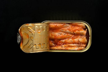 top view of a can of pickled sardines on grey background