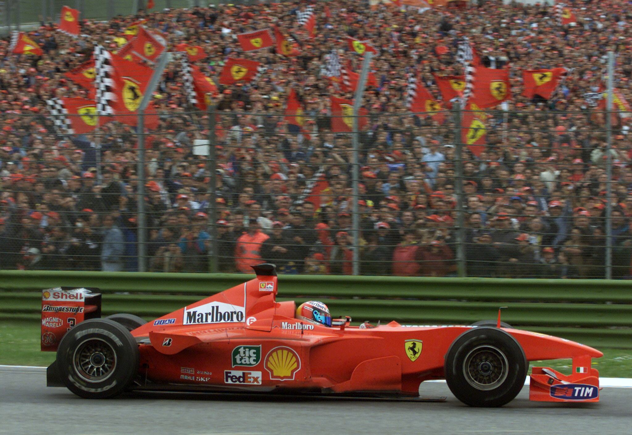 Schumi generó una fiebre sin igual de los tifosis de Ferrari, que durante cinco temporadas celebraron diez títulos mundiales. La postal es de Imola 2000 (REUTERS/Paolo Cocco/File Photo)