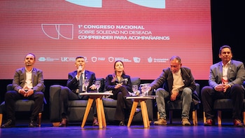 Cinco personas sentadas en un escenario. Un hombre habla por micrófono, con una pantalla de fondo que muestra '1° Congreso Nacional sobre Soledad No Deseada'