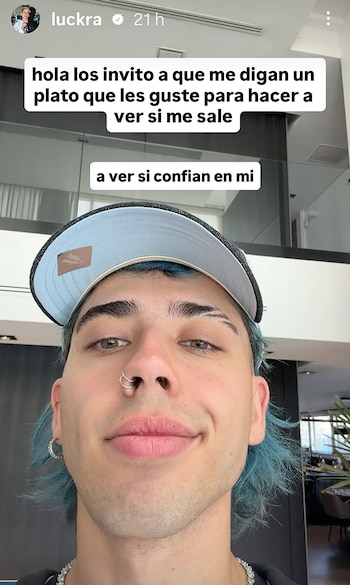 Un hombre con cabello azul y gorra mira a la cámara en una autofoto con recuadros de texto superpuestos