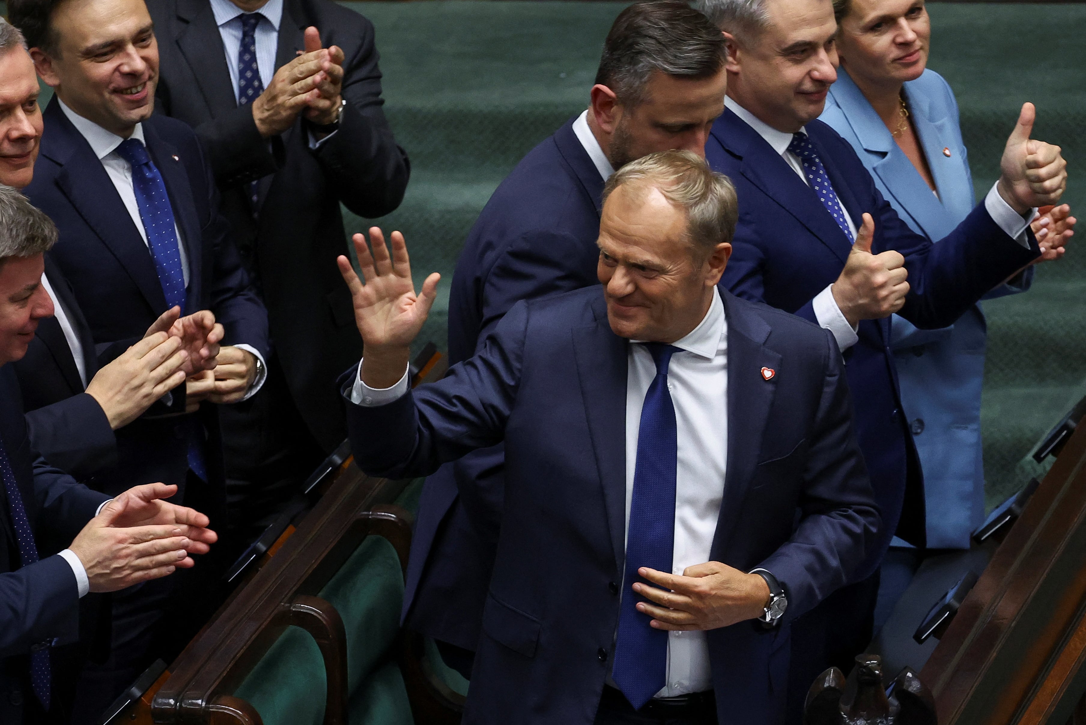El primer ministro polaco Donald Tusk saluda a los aliados en el Parlamento tras una moción de confianza a favor de su gobierno en Varsovia, Polonia, este 11 de junio de 2025 (REUTERS/Kacper Pempel)