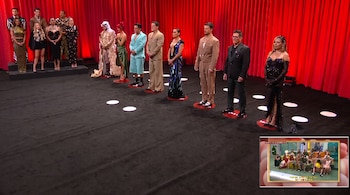 Personas vestidas de gala permanecen de pie sobre marcas circulares en un escenario con telón rojo y alfombra negra.