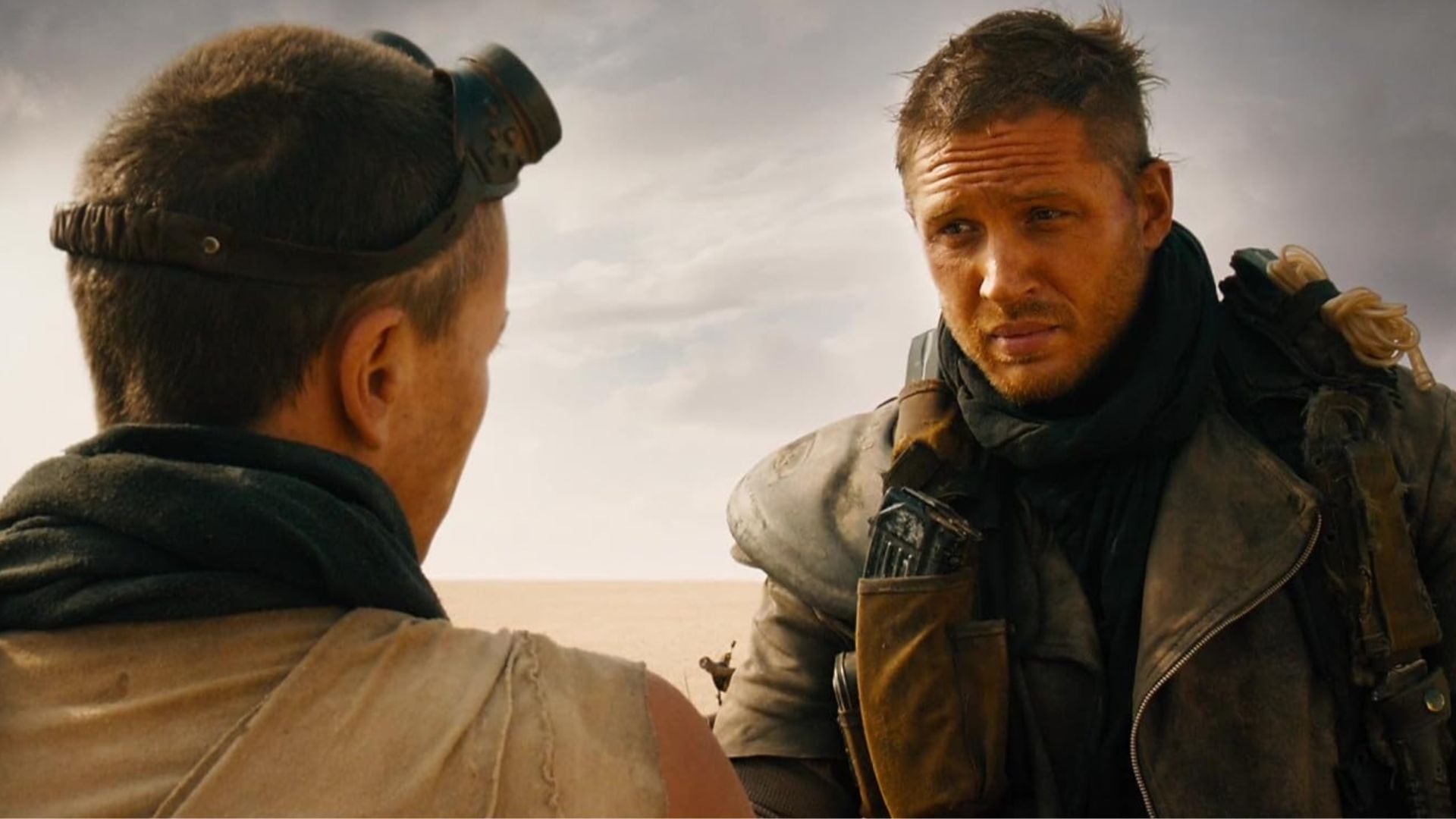 Charlize Theron (de espaldas) y Tom Hardy en