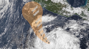 Vista satelital de nubes sobre el océano Pacífico con una franja naranja que marca la ruta prevista de un ciclón y la costa de México.