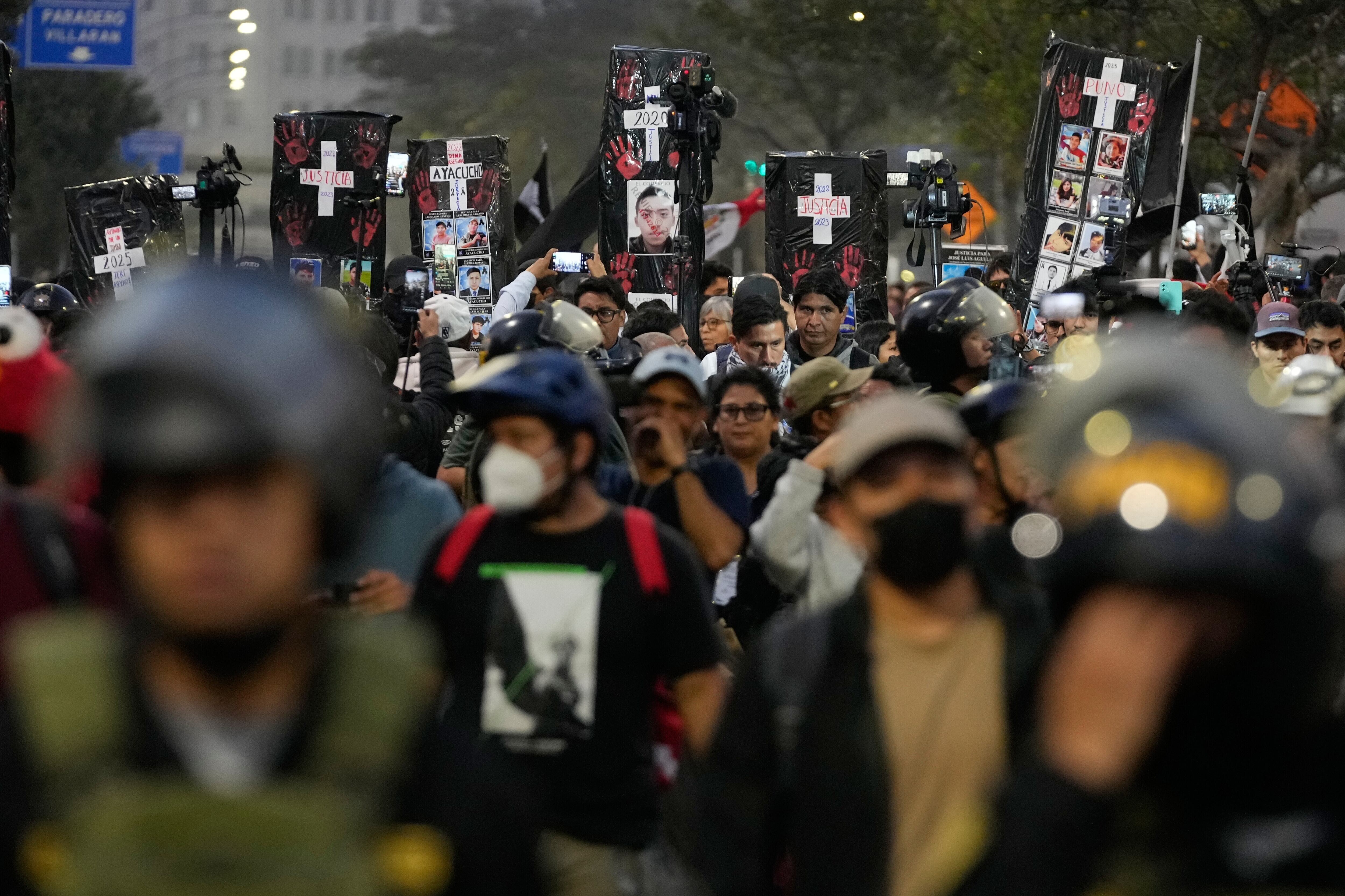 Manifestantes cargan féretros de cartón en representación de las víctimas de la violencia política durante una protesta en contra del presidente peruano interino, José Jerí, el sábado 25 de octubre de 2025, en Lima. (AP Foto/Martín Mejía)