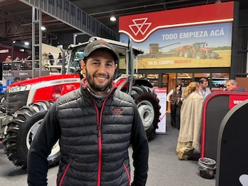 Un hombre con gorra y chaleco negro sonríe frente a un tractor rojo. Detrás hay un cartel de Massey Ferguson con la frase "TODO EMPIEZA ACÁ"