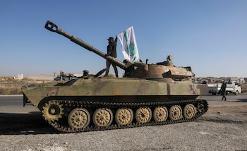 Un combatiente rebelde sobre un vehículo militar mientras porta una bandera de Hayat Tahrir al-Sham en la ciudad de Saraqeb, en la provincia noroccidental de Idlib (REUTERS/Mahmoud Hassano)
