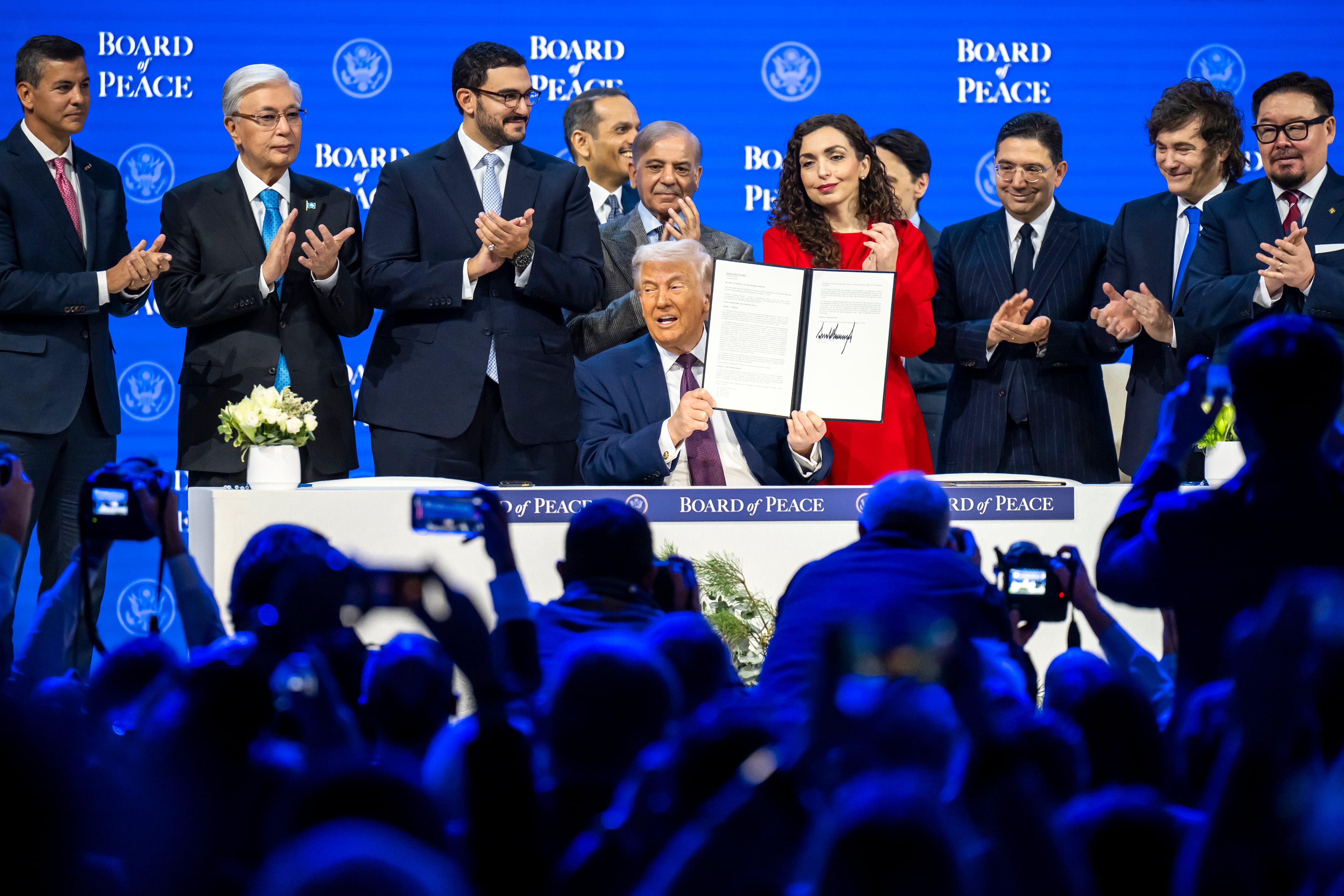 El presidente de Estados Unidos, Donald Trump, (centro) muestra la carta en la que se ha firmado la iniciativa Junta de Paz, rodeado de un grupo de líderes mundiales, durante la semana en la que se celebra el Foro de Davos EFE/EPA/GIAN EHRENZELLER
