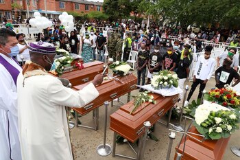 Un sacerdote rocía agua bendita