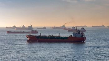 Numerosos buques mercantes y petroleros anclados en el mar abierto, con el cielo brumoso en un día con poca visibilidad