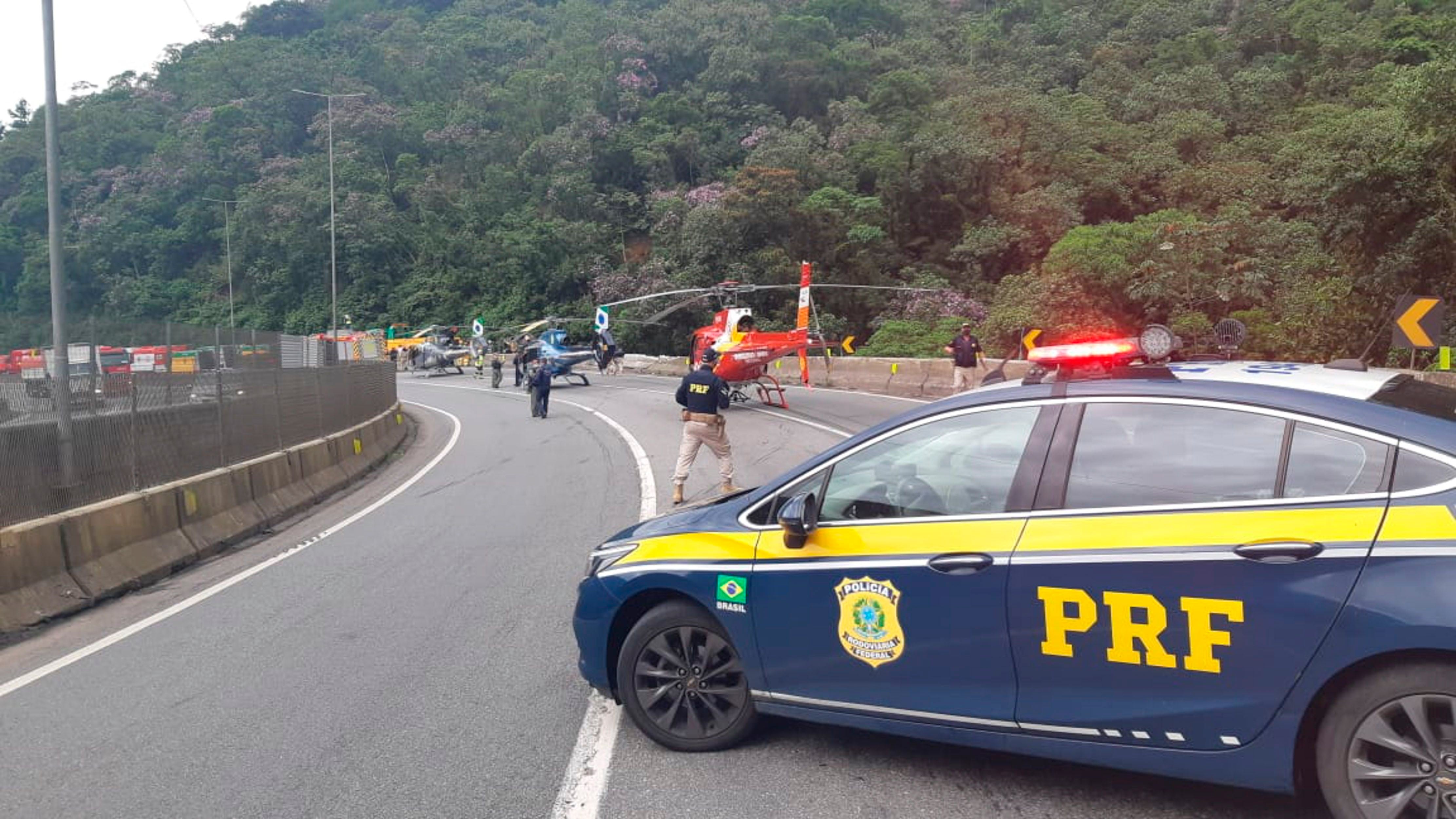 Fotografía cedida este lunes por la Policía Rodoviaria Federal (PRF) en la que se registró a miembros de este cuerpo policial al atender el lugar donde se accidentó un autobús, en el litoral del estado brasileño de Paraná (Brasil). EFE/PRF