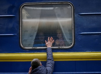 Un padre posa la mano sobre la ventana de un tren mientras despide a sus hijos en la estación de Kiev. Las familias se desangran mientras las tropas invasoras de Vladimir Putin multiplican sus ataques (Reuters)