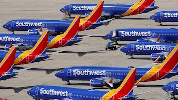 Vista aérea de varios aviones Southwest Airlines azules y blancos con colas rojas y amarillas, estacionados en un pavimento de asfalto gris