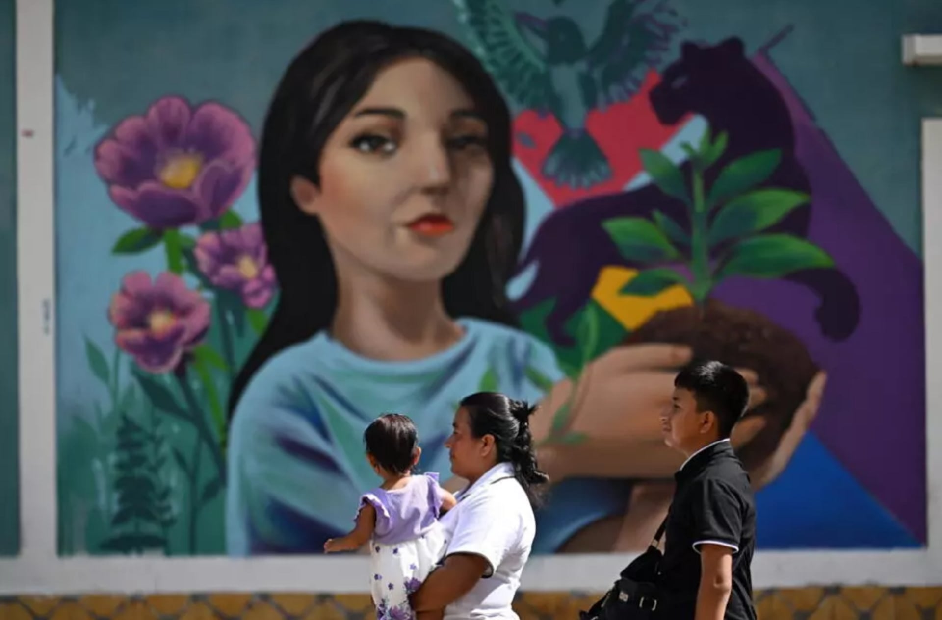 Personas locales pasan frente a un mural pintado durante un festival en Concepción de Ataco, Ahuachapán, El Salvador, el 15 de agosto de 2026 (Crédito: Marvin Recinos / AFP)