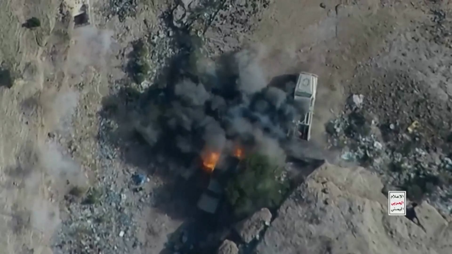 Un ataque en una zona árida de Yemen destruye un vehículo militar entre humo negro y llamas durante el conflicto armado.