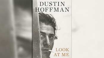Fotografía en blanco y negro de Dustin Hoffman con un cigarrillo en la boca, junto a los textos DUSTIN HOFFMAN y LOOK AT ME
