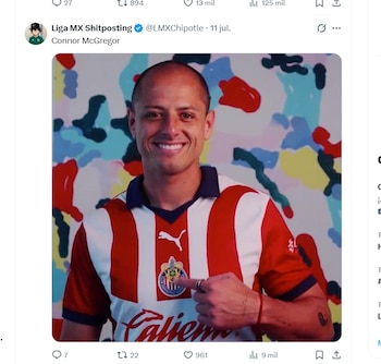 Hombre con camiseta de fútbol a rayas rojas y blancas, sonriendo y apuntando al escudo del club en su pecho. Fondo con manchas de colores abstractas