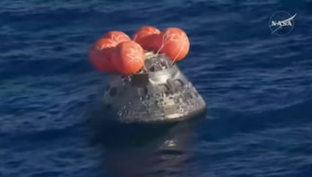 La nave Orión flota en el Pacífico, mientras los astronautas esperan a ser extraídos por personal especializado