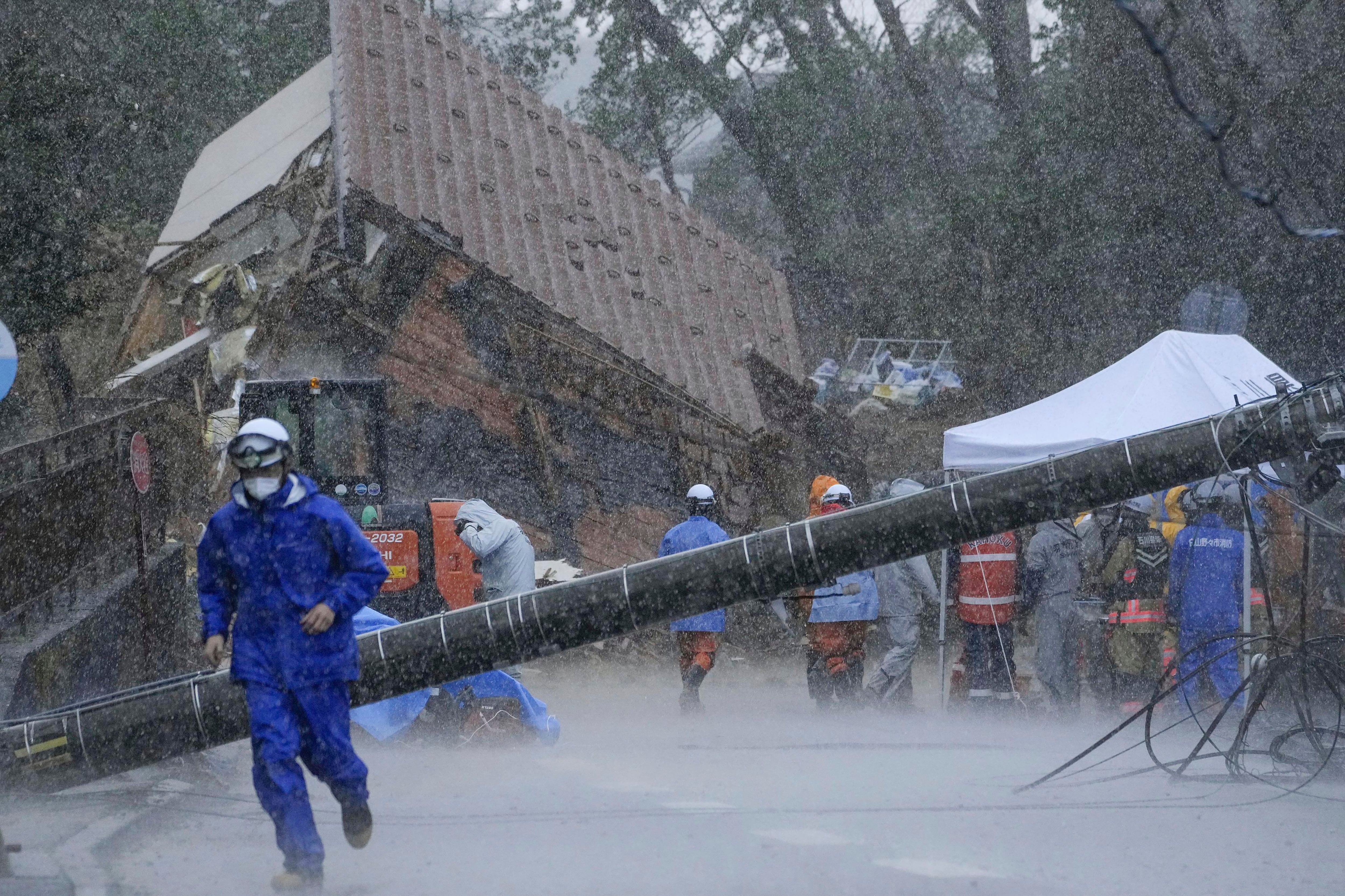 Rescuers halt a search operation due to a strong rain at the site of a landslide in Anamizu town, Ishikawa prefecture, Japan Saturday, Jan. 6, 2024. Monday’s temblor decimated houses, twisted and scarred roads and scattered boats like toys in the waters, and prompted tsunami warnings. (Kyodo News via AP)