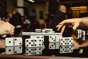 Clientes juegan dominó en el