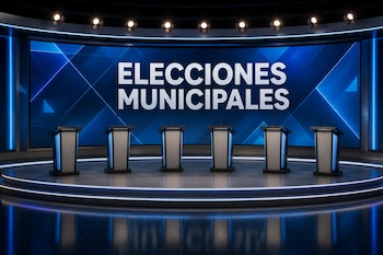 Seis atriles con micrófonos en un escenario frente a una pantalla azul gigante con las palabras Elecciones Municipales en letras blancas.