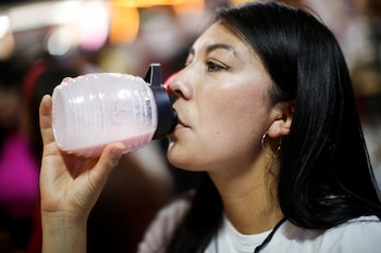 A woman drinks Pulque, a