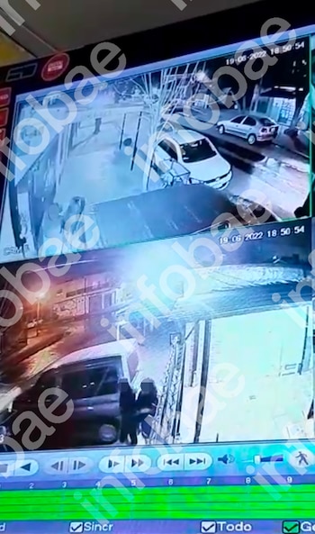 Pantalla de monitor muestra dos grabaciones de cámara de seguridad, con coches, personas y una calle. Controles de reproducción, barra de tiempo y fecha 19-06-2022 18:50:54