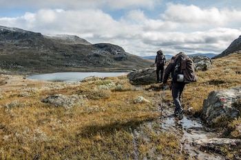 Dos senderistas en un camino cercano al río (Pexels)