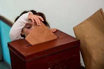 Un niño deposita una papeleta en una urna de un colegio electoral en Canelones (REUTERS/Mariana Greif)