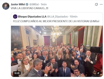 Captura de una publicación en la red social X que incluye un video de un grupo de personas en traje aplaudiendo dentro de un salón