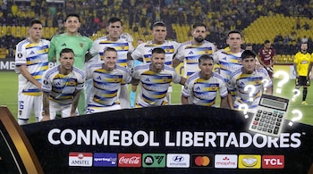 Jugadores de Boca Juniors posando en el campo de juego con un cartel de CONMEBOL Libertadores, junto a una calculadora y signos de interrogación.