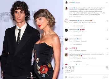 Taylor Swift con vestido negro sin tirantes y bordados florales posa junto a un hombre de traje oscuro en un evento