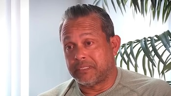 Hombre de mediana edad, Luis Salazar, con cabello gris y barba de pocos días, mirando hacia la derecha. Viste una camiseta verde y hay plantas al fondo
