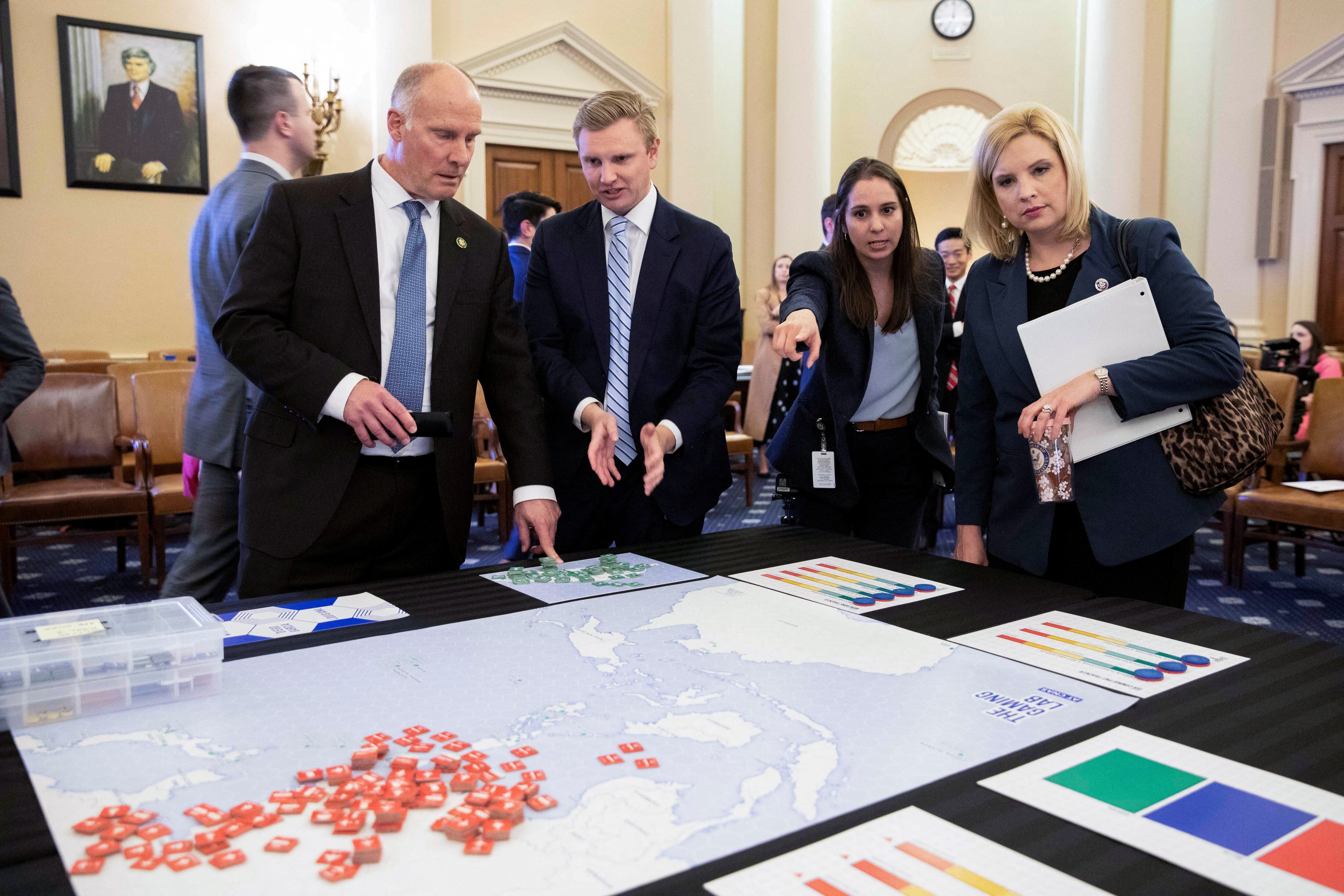 Los representantes estadounidenses John Moolenaar (republicano por Michigan) y Ashley Hinson (republicano por Iowa) revisan un mapa con sus asesores durante una reunión del Comité Selecto de la Cámara de Representantes sobre la Competencia Estratégica entre Estados Unidos y el Partido Comunista Chino sobre el