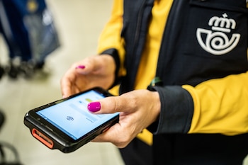 Imagen de archivo de una trabajadora de Correos con un móvil. (Diego Radamés/Europa Press)