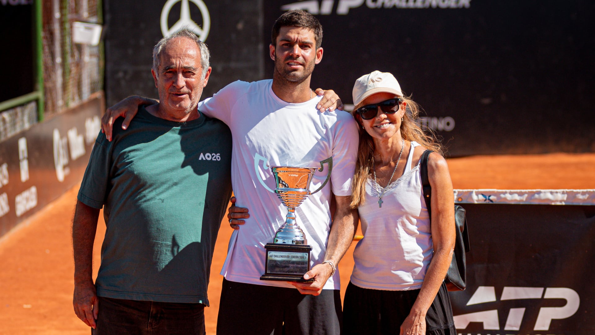 Facundo Díaz Acosta posa con el trofeo junto a sus padres tras consagrarse campeón en el AAT Challenger Tigre II (Crédito: Prensa AAT)